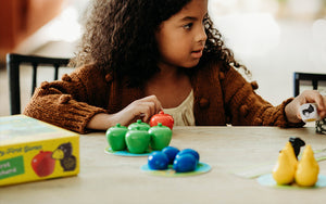Girl sitting at table playing HABA My Very First Games First Orchard